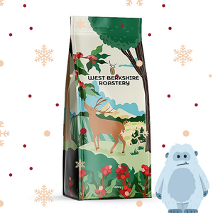 Coffee bag with nature-themed design and West Berkshire Roastery branding, accompanied by a Yeti toy.