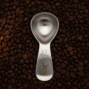 Metal measuring spoon with '2 T 30ml' marking on a white background
