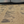 Dry coffee beans spread out on a surface with a black tarp in the background